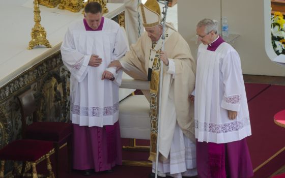 Pope Francis is helped walking as he celebrates the canonization Mass for 10 new saints in St. Peter's Square at the Vatican May 15. (AP/Gregorio Borgia)